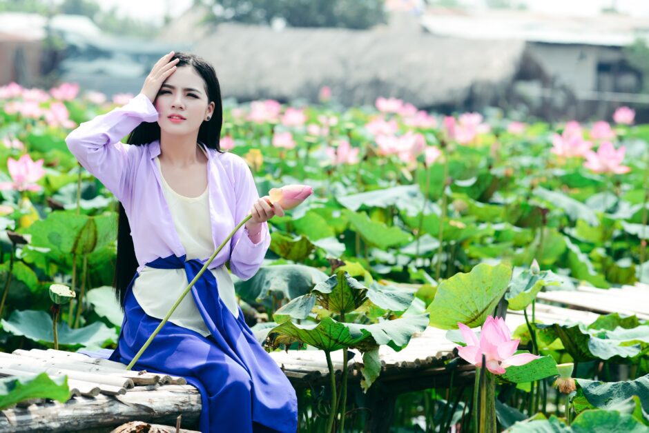 蓮の花の前で微笑む女性