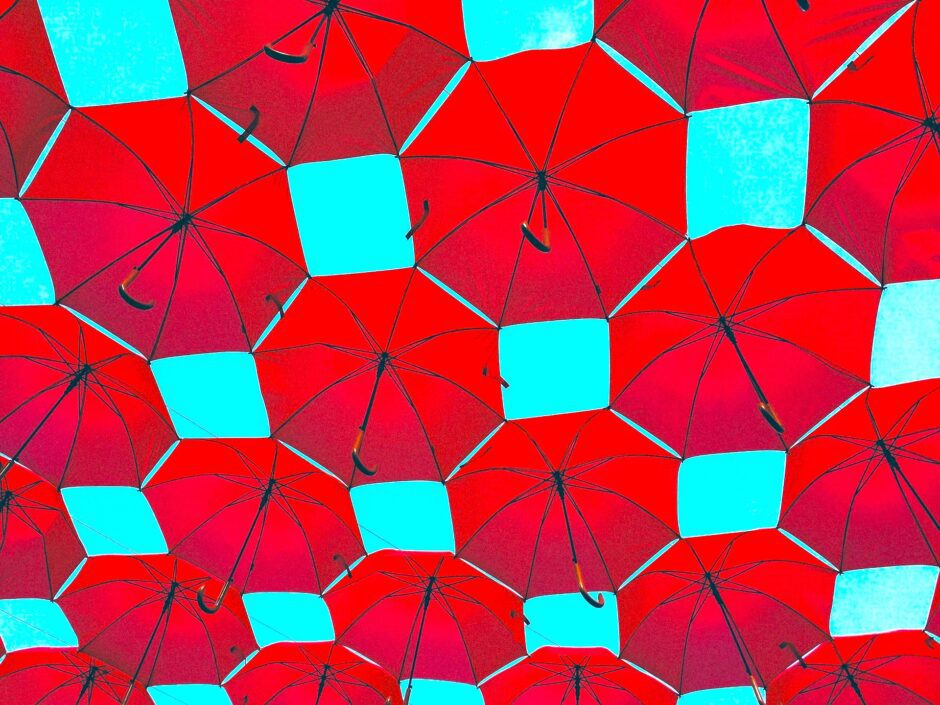 青空に浮かぶたくさんの赤い傘
