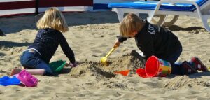 砂遊びで穴を掘る2人の子ども